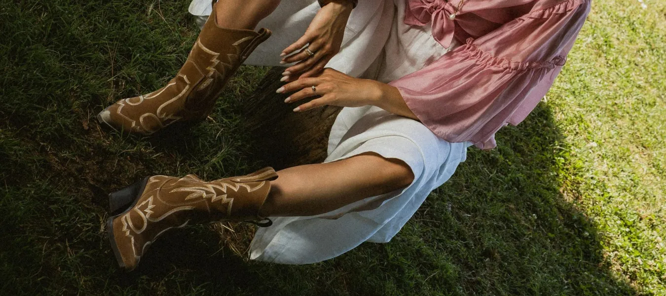 Modne buty damskie na jesień – stylizacja z brązowymi kowbojkami, białą spódnicą i różową bluzką