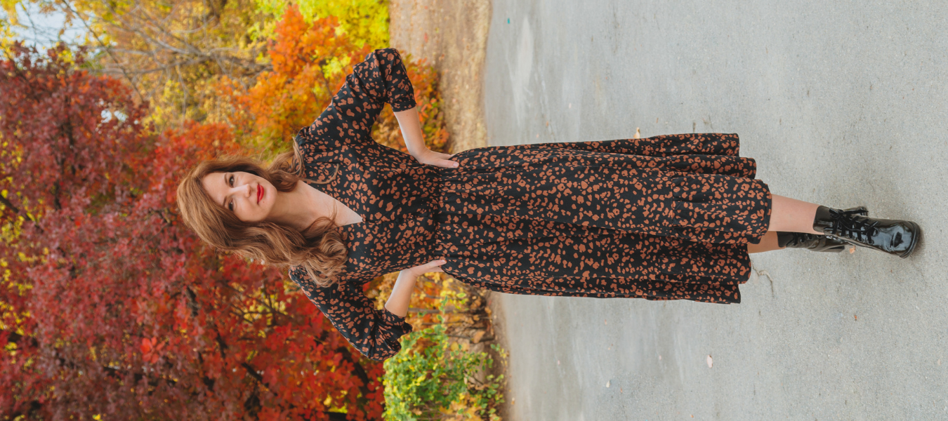 Jesienna stylizacja – długa czarna sukienka w brązowy wzór i czarne lakierowane botki damskie, modne buty na jesień 2025