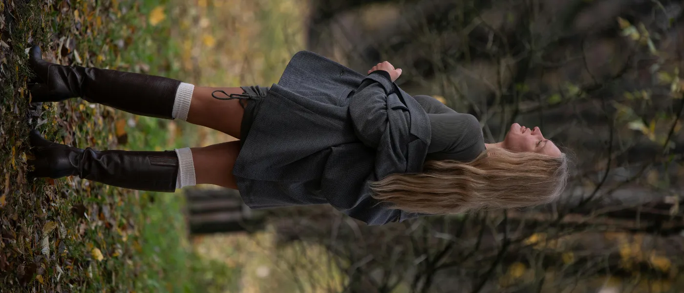 Elegancka stylizacja na jesień 2025 - Czarne kozaki z wystającymi podkolanówkami i szarą marynarką