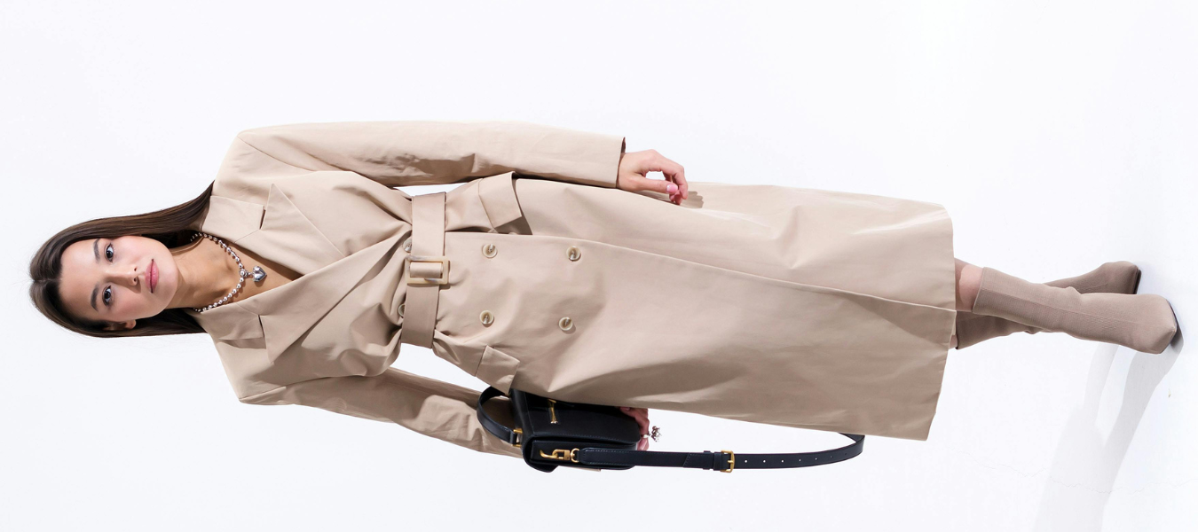 Elegancka stylizacja z beżowym trenczem, długimi botkami i czarną torebką – porady jak dobrać torebkę do butów