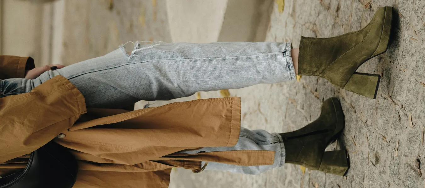 Zielone buty damskie – zamszowe botki na grubym obcasie zestawione z jeansami i trenczem w jesiennej stylizacji