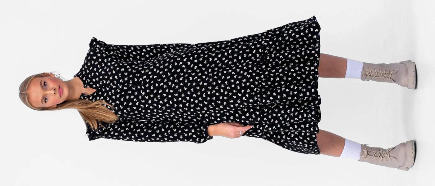 Czarna sukienka maxi w drobny print zestawiona z beżowymi botkami – stylizacja na jesień 2025