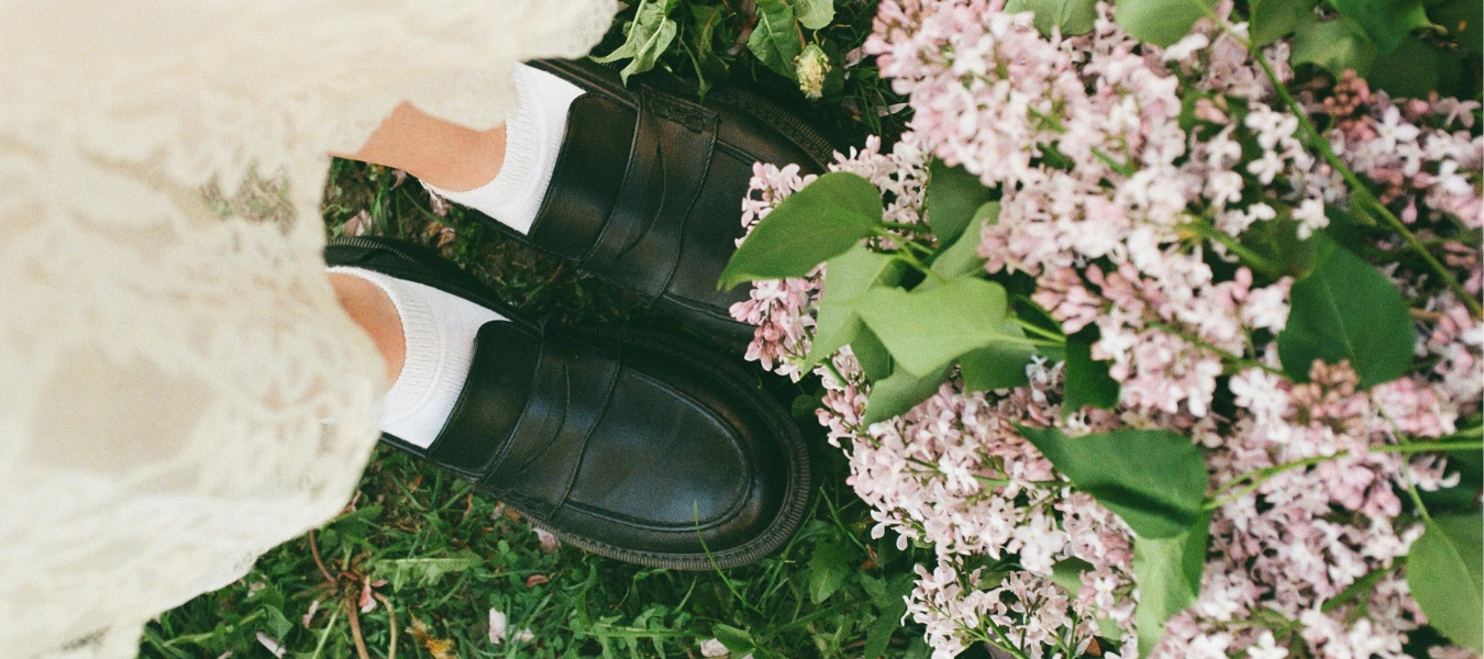 Czarne loafersy damskie zestawione z białymi skarpetkami i koronkową sukienką – stylowa propozycja na jesień w romantycznym wydaniu