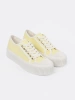 Yellow lace-up sneakers with a thick sole
