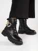 Black combat boots with a gold chain