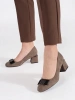 Beige block heeled pumps with a bow