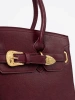 Burgundy handbag with decorative buckle in gold color