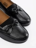 Black slip-on loafers with a bow
