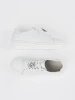 White leather sneakers with a pin by Sergio Leone